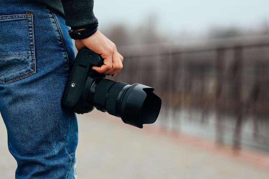 Person holding a camera close-up with his hand